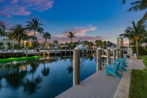 a body of water with benches and palm trees at Seven Palms Waterfront- Private Dock, Heated Pool & Lanai -Walk to beach! by Maven Vacation Rentals in West Palm Beach