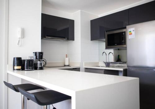 a kitchen with a white counter and a refrigerator at Hermoso departamento amoblado en Concón 2D/2B/1E in Concón