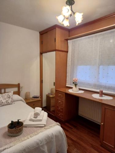 1 dormitorio con 1 cama, ventana y escritorio en Apartamento Penedo, camino portugus-CON PLAZA DE GARAJE GRATIS, en Santiago de Compostela