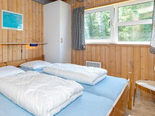 2 Betten in einem Zimmer mit Holzwänden und Fenstern in der Unterkunft Three-Bedroom Holiday home in Fjerritslev 21 in Torup Strand