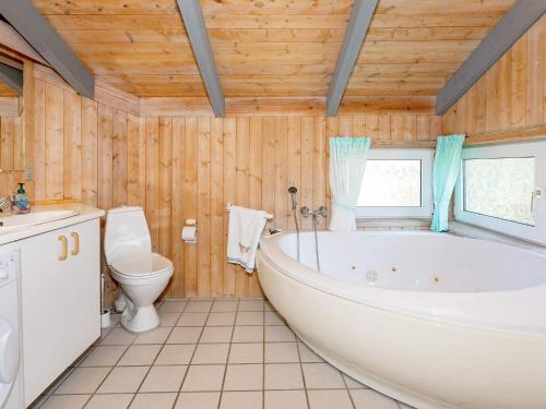 a bathroom with a tub and a toilet at Secluded Haven in Thorup - By Traum Ferienwohnungen in Torup Strand