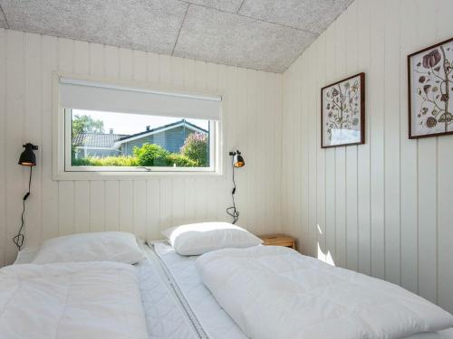 two beds in a bedroom with a window at Holiday home Rønde IX in Rønde