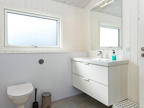 La salle de bains est pourvue de toilettes, d'un lavabo et d'une fenêtre. dans l'établissement Holiday home Rønde IX, à Rønde