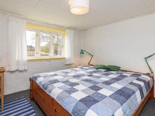 1 dormitorio con 1 cama a cuadros en una habitación en Holiday home Bedsted Thy IV, en Bedsted Thy