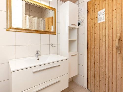 een badkamer met een wastafel en een spiegel bij Holiday home Væggerløse CCXVI in Bøtø By