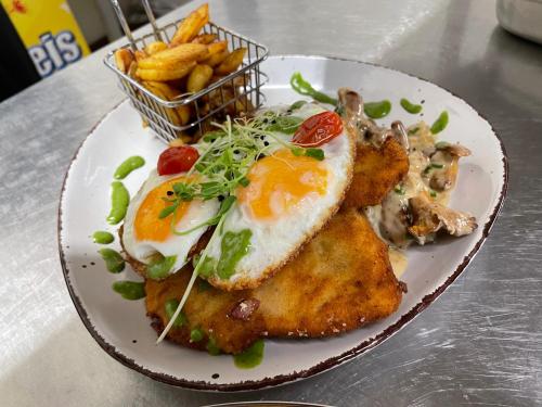 a plate of food with fried eggs and french fries at Niemeyers Landgasthof und Pension in Süderstapel