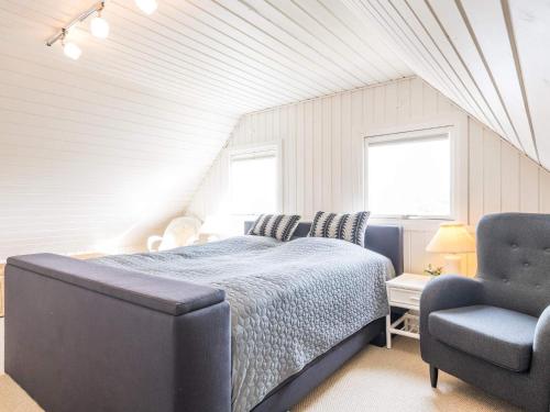 a bedroom with a bed and a chair at Holiday home Fanø CCVIII in Fanø