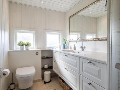 a bathroom with a toilet and a sink and a mirror at Holiday home Fanø CCVIII in Fanø