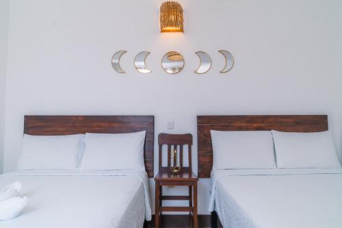 1 dormitorio con 2 camas, silla y lámpara de araña en Casa Ramona en Flores