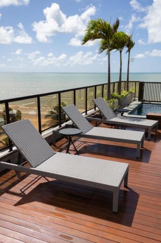 a deck with chaise lounge chairs and the ocean at Arpoar Suítes 330 in João Pessoa