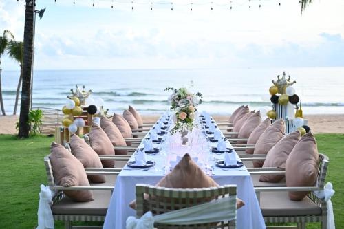 a long table with chairs at the beach at Crowne Plaza Phu Quoc Starbay by IHG in Phu Quoc