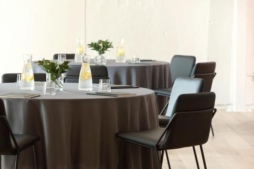 a conference room with tables and chairs with drinks on them at Kimpton Hotel Fontenot by IHG in New Orleans