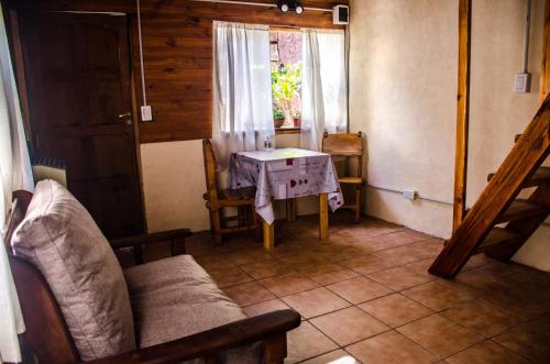 a living room with a couch and a table at Cabaña BIKO in El Bolsón