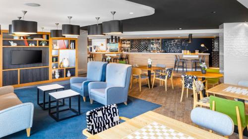 un ristorante con sedie blu e una sala da pranzo di Holiday Inn Amsterdam - Arena Towers, an IHG Hotel ad Amsterdam
