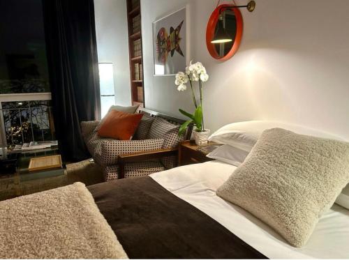 a bedroom with a bed and a living room with a chair at Niko Rooms in Santa Cruz de Tenerife