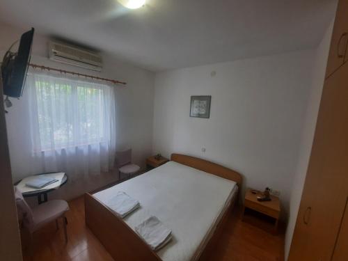a small bedroom with a bed and a window at Apartments with a parking space Makarska - 12211 in Makarska