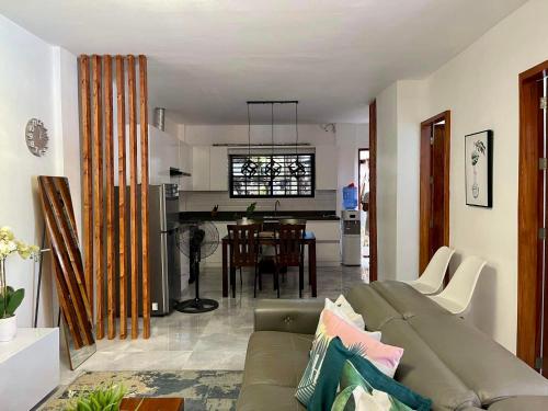 uma sala de estar com um sofá e uma cozinha em MARLS PLACE FULLY FURNISHED, 4 mins walk to SM MALL and GAISANO MALL FB name Marls Place em Butuan