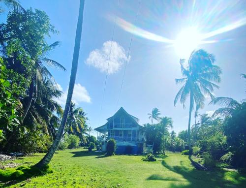 a house in the middle of a field with palm trees at Islander House on Rocky Cay Beach in San Andrés