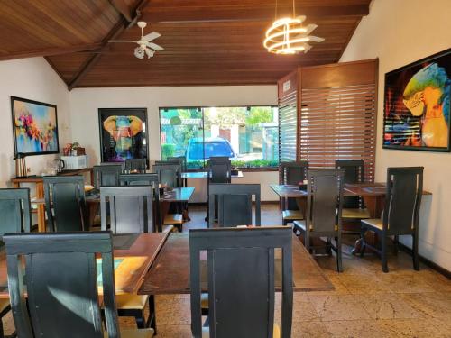 una sala da pranzo con tavoli e sedie in legno di Pousada Costa Del Sol a Búzios