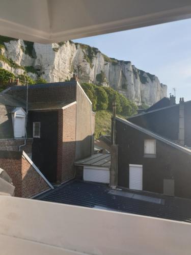 une vue d'un bâtiment avec une montagne en arrière-plan dans l'établissement Notre nid - Grande terrasse privée en bord de mer, au coeur du quartier historique du Tréport ! Wifi, au Tréport
