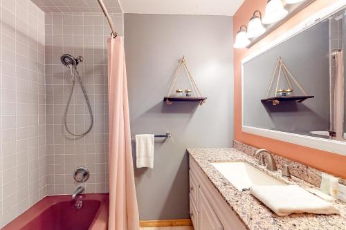a bathroom with a tub and a sink and a mirror at Nature's Nook in Damariscotta