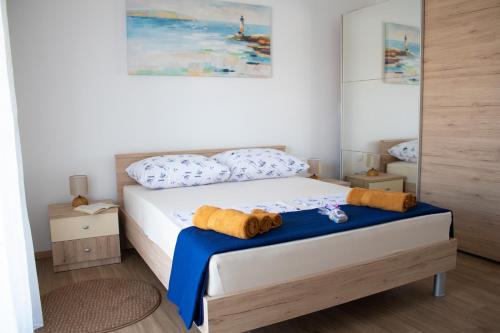 a bedroom with a bed with blue and white sheets at Villa Koraljka in Vodice