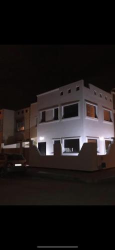 a white building at night with its lights on at Aya in Saïdia