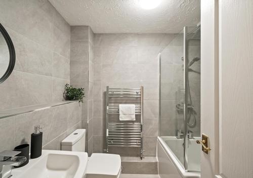 y baño con ducha, aseo y lavamanos. en East London House near tube with parking, en Londres