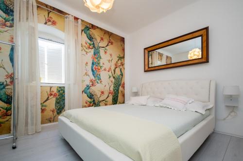 a white bedroom with a bed and a mirror at Holiday house with WiFi Sali, Dugi otok - 17797 in Sali