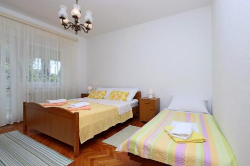 1 Schlafzimmer mit 2 Betten und einem Kronleuchter in der Unterkunft Apartments with a parking space Bribir, Novi Vinodolski - 19862 in Bribir