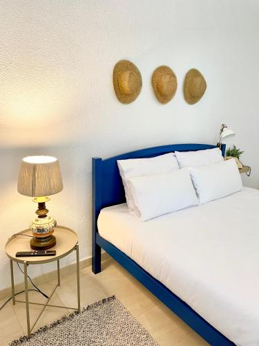 a bedroom with a blue bed and a table with a lamp at Detailed Villa - In Vilamoura's Heart in Vilamoura