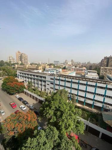 ein großes Gebäude mit Autos auf einem Parkplatz in der Unterkunft Cozy 3-BR Apartment for families only in Agouza! in Kairo