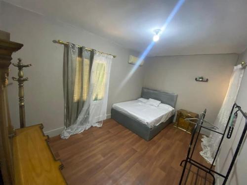 ein Schlafzimmer mit einem Bett und einem Licht an der Decke in der Unterkunft Cozy 3-BR Apartment for families only in Agouza! in Kairo