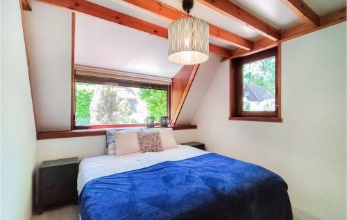3 Bedroom Stunning Home In Rekem-lanaken في Bovenwezet: غرفة نوم بسرير ازرق ونوافذ