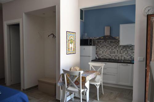 kuchnia ze stołem i krzesłami w pokoju w obiekcie Casacecilia relax w Syrakuzach