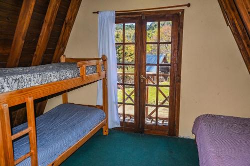 1 dormitorio con 2 literas y ventana en Cabañas Rio Hermoso en Cerro Negro