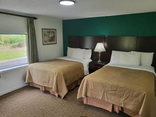 Parsons的住宿－青松汽車旅館，酒店客房设有两张床和窗户。