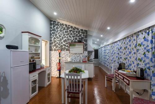 a kitchen with white cabinets and a table with chairs at Casa do Calço in Ponta Delgada