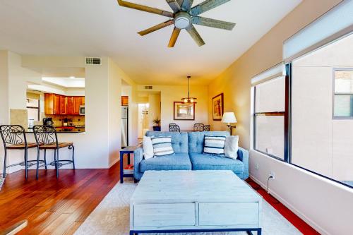 sala de estar con sofá azul y ventilador de techo en Canyon Views Forever en Tucson