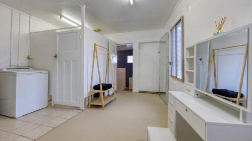 a room with white walls and a hallway with mirrors at Desert Hideaway - White Cliffs in White Cliffs