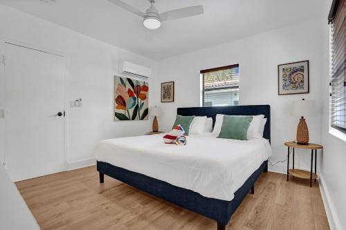 a bedroom with a large bed with white sheets and green pillows at Waves On Walnut - Beach Access in Hollywood