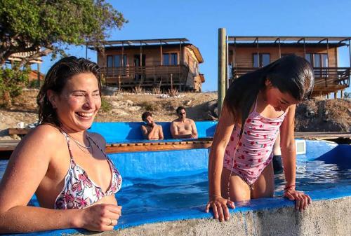 una mujer y una niña en una piscina en Ocho Aguilas Eco Lodge en Guanaqueros