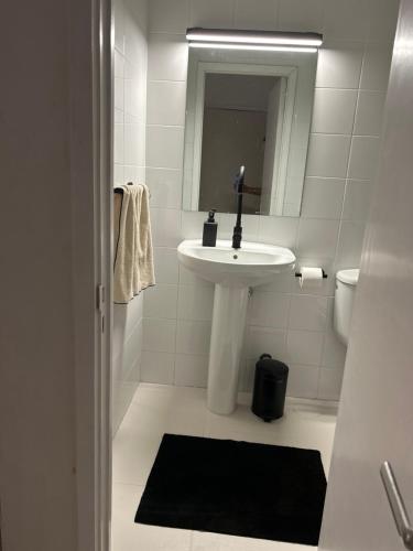 Baño blanco con lavabo y espejo en Niko Rooms en Santa Cruz de Tenerife