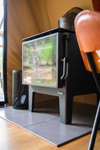 a television sitting on top of a desk with a chair at Moogie Glamp in Moogerah