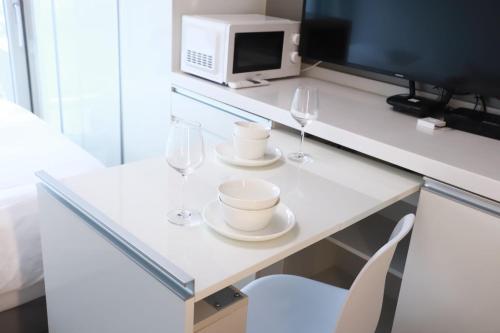 einen Tisch mit zwei Weingläsern und eine Mikrowelle in der Unterkunft Shine residence in Incheon