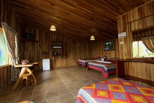 a bedroom with two beds and a table in a room at Historias Lodge in Monteverde Costa Rica
