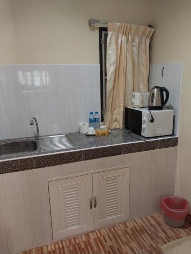 eine Küchentheke mit einer Spüle und einer Mikrowelle in der Unterkunft Sofia Garden Resort in Ko Chang