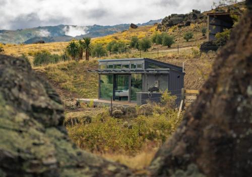 a small house sitting on top of a hill at Tāima PurePod in Cromwell