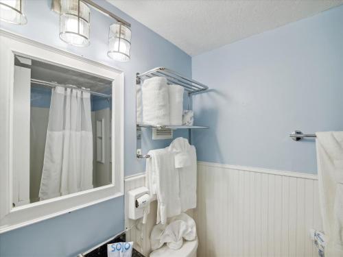 ein blaues Bad mit einem WC und einem Spiegel in der Unterkunft Victorian 3101- Paradise Cove in Galveston