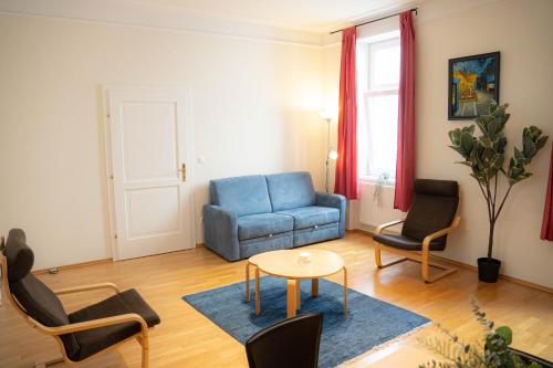 a living room with a blue couch and chairs at Bright - Colorful - Near Centrum - Restify 6&7 in Vienna